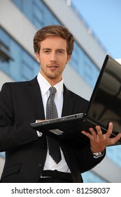 Man In Suit Carrying A Laptop