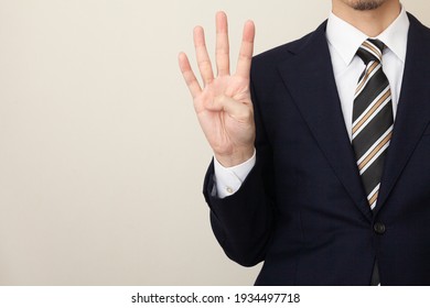 A Man In A Suit With Four Fingers