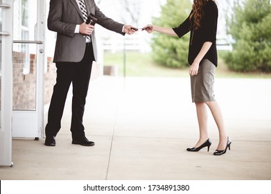 A Man In Suit Handing Out A Church Pamphlet To A Woman