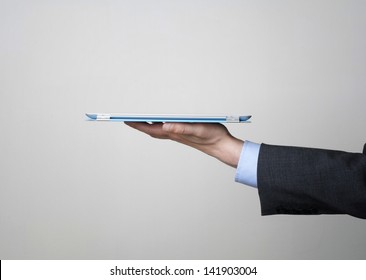 Man in a suit holding a digital tablet, close up side view