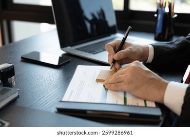 A man in a suit is holding a stack of papers and a pen. He is likely working on a project or preparing for a meeting. Concept of professionalism and focus, as the man is fully engaged in his task


