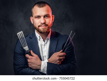 A Man In A Suit Holds A Chef's Knife.