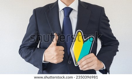 A man in a suit with a Japanese beginner's mark.