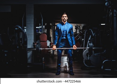 Man In Suit Lifting Heavy Weight In The Gym