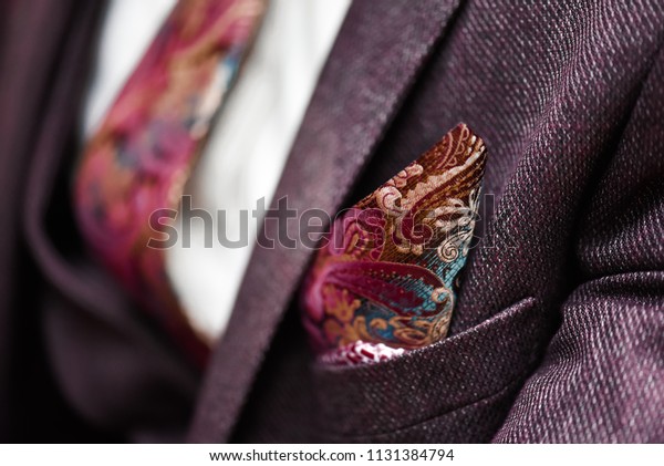 Man in suit, plaid texture, bow tie and pocket
square, close up white
background