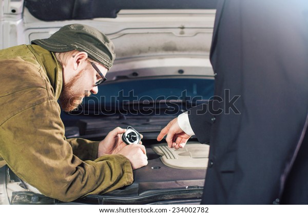 Man in Suit\
Pointing Motor Oil Slot for\
Mechanic