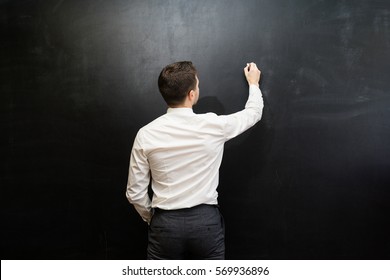 Man In Suit Pointing Something,writing On Chalkboard,back View,isolated.Copyspace Blank,back View