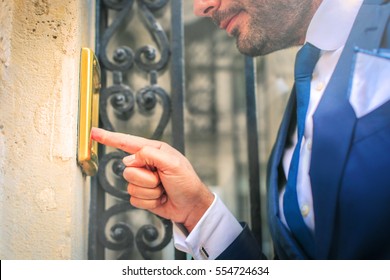 Man In Suit Ringing The Door Bell 