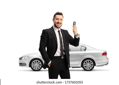 Man In A Suit Showing Car Keys And And Standing In Front Of A Silver Car Isolated On White Background