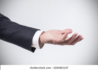 Man in suit shows outstretched hand with open palm. - Powered by Shutterstock