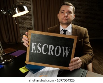 A Man In A Suit Shows A Sign Escrow.