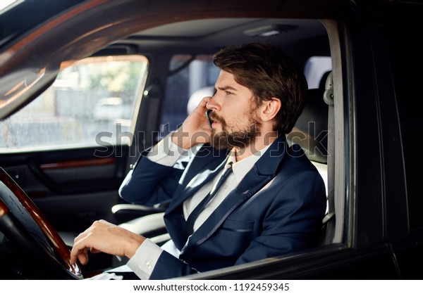 man in a suit sitting in the car and\
talking on the phone                              \
