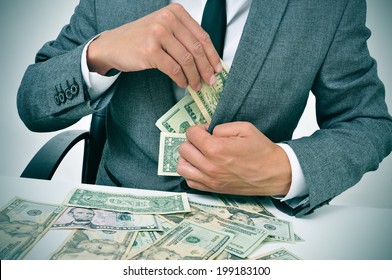 man in suit sitting in a desk full of dollar bills getting them in his jacket