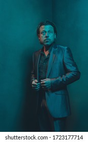 Man In Suit Stands In Corner Of Empty Room. Serious And Pensive Expression.