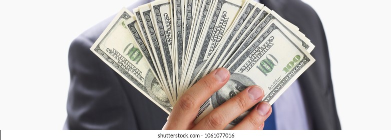 Man in suit and tie hold in arm pack of hundred dollar bills closeup. Stock market exchange earn pile rich present gift employer prepayment service gratitude concept