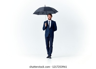 a man in a suit and tie is standing under an umbrella                           