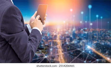 A man in a suit uses a smartphone against a blurry city skyline background. The background is illuminated with bright lights and has lines that form a network. - Powered by Shutterstock