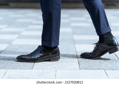 A man in a suit walking in a business district - Shutterstock ID 2157020811