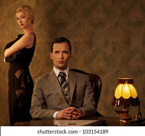 Man In Suit  With Woman Behind Him.