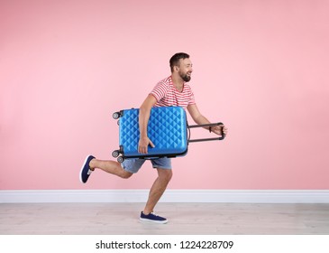 Man With Suitcase Running Near Color Wall. Vacation Travel