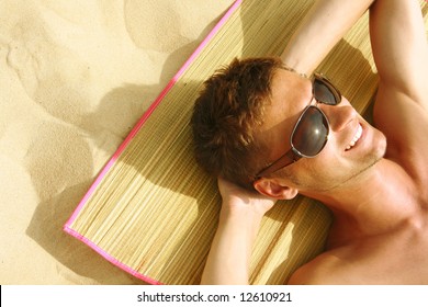 Man Sunbathing On The Beach