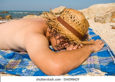 A Man Sunbathing On The Beach 