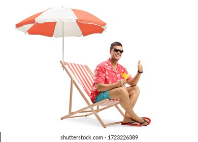 Man with sunglasses drinking cocktail and sitting under umbrella on a deckchair isolated on white background - Powered by Shutterstock