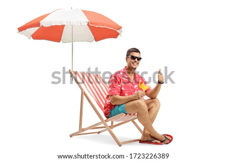 Man with sunglasses drinking cocktail and sitting under umbrella on a deckchair isolated on white background