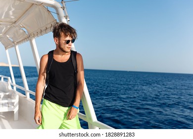 Man In Sunglasses Green Shorts And Black Tank Top On A Yacht In The Sea.