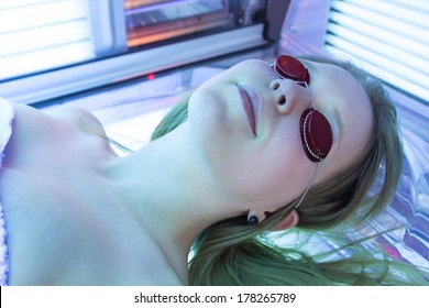 Man With Sunglasses On Tanning Bed In Solarium