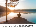 Man in the sunset. Alone man sitting on a lake with cup of coffee. Morning and sunrise on beautiful nature. Lake and mountains. happy man. inspiration concept, enjoy life. Calm and peace.