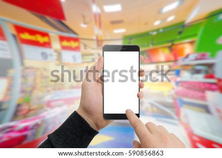 Man in supermaket holding modern phone in hands. Shopping online concept, free space for text. Empty white screen