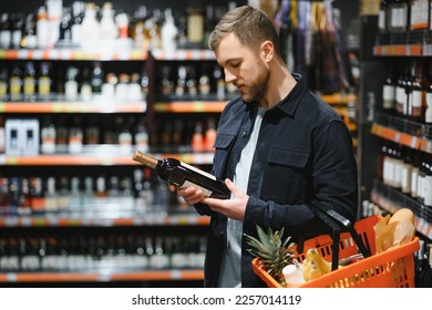 Man in a supermarket choosing a wine. - Powered by Shutterstock