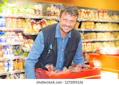 Man In A Supermarket Employee Store Fills Up The Department For Customers