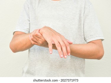 a man support his hand and arm that having symptoms of pain,numbness,weakness,paralysis,muscle disorder, concept of Guillain barre syndrome caused by autoimmune disorder - Shutterstock ID 2027371973