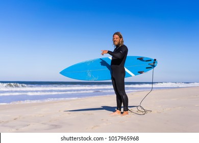 Man With Surf Board On The Ocean Shore. Surfer In A Wet Suit. Nazare, Portugal.