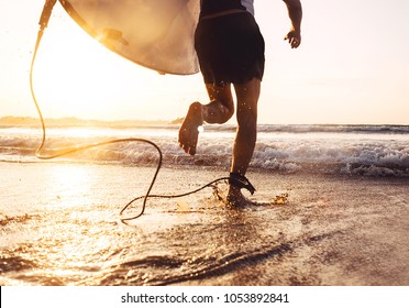 Man surfer run in ocean with surfboard. Active vacation, health lifestyle and sport concept image
