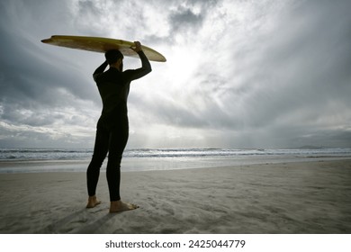 Man, surfer and wetsuit at beach for waves, sport or exercise on sandy shore in outdoor fitness. Rear view of male person or athlete with surfboard for surfing on ocean coast, sea or water in nature - Powered by Shutterstock