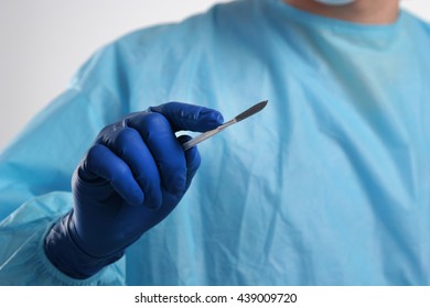 Man Surgeon Holds A Scalpel.