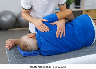 Man In A Surgery Examining The Upper Back Of A Mature Man