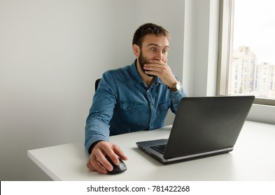 A man surprised working on a laptop - Shutterstock ID 781422268