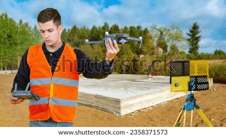Man surveyor with quadrocopter. Guy launches surveying drone. Man is holding quadcopter remote control. Builder stands near foundation. Surveyor uses quadrocopter. Surveyor at construction site house