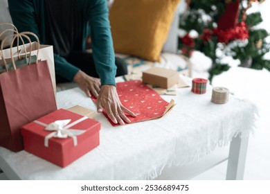 Man in sweater wrapping christmas presents with eco paper girl packing christmas gifts Xmas holiday concept. - Powered by Shutterstock