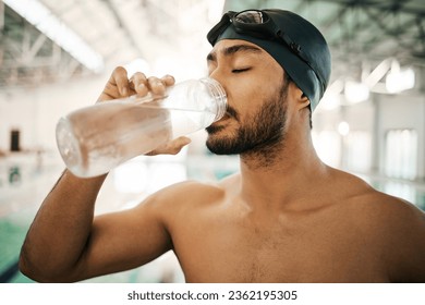 Man, swimmer and drinking water for hydration, exercise or training workout at indoor swimming pool. Active and thirsty male person or athlete with mineral drink for sustainability, fitness or cardio - Powered by Shutterstock