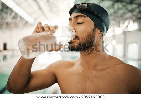 Man, swimmer and drinking water for hydration, exercise or training workout at indoor swimming pool. Active and thirsty male person or athlete with mineral drink for sustainability, fitness or cardio
