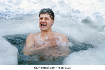 A Man Is Swimming In An Ice Hole In The Winter