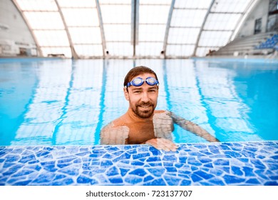 Man Swimming In An Indoor Swimming Pool.