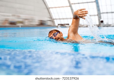 Man Swimming In An Indoor Swimming Pool.