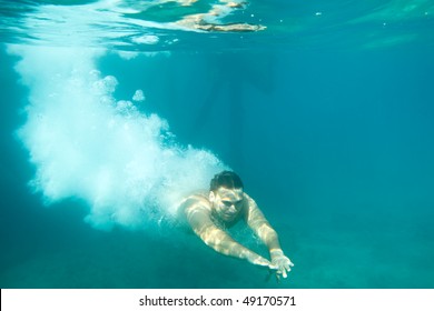 Man Swimming Under Water, Just Jumped In From Pier In Open Water.