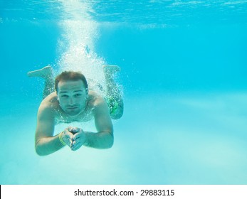 Man Swimming Under Water In Pool